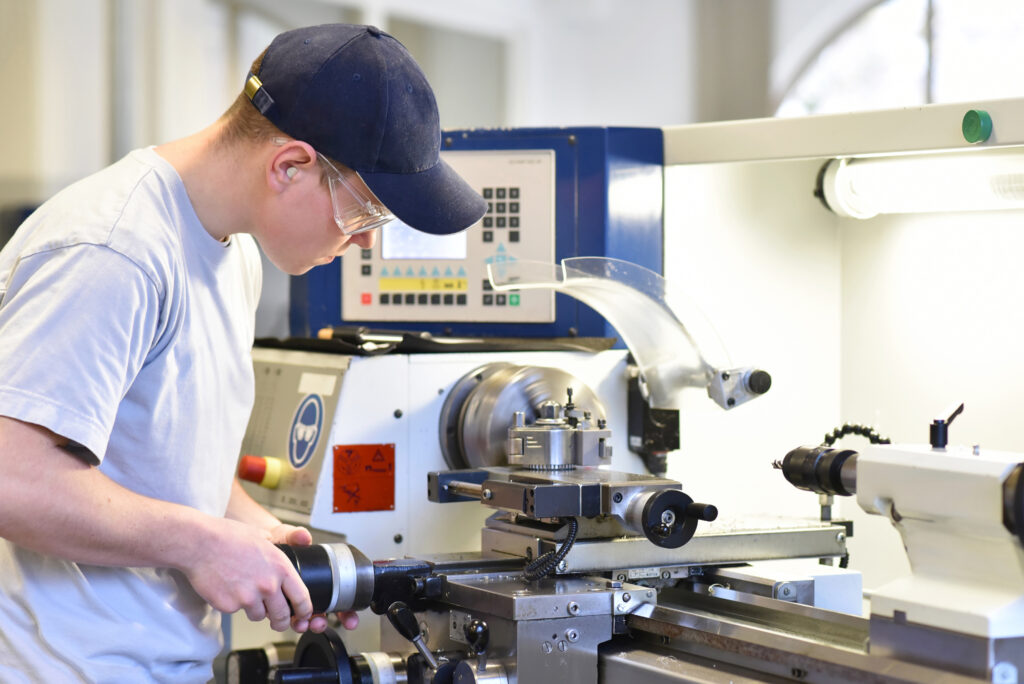 turning machine tool in use by man in vocational training
