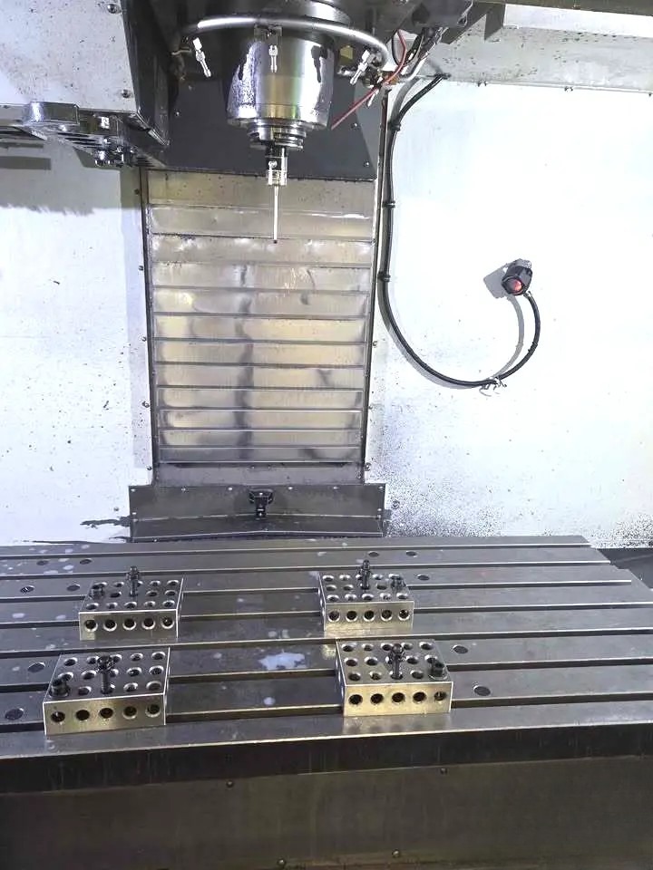 Interior of Haas VF-5/50XT showing spindle, T-slot table, way covers, and setup blocks